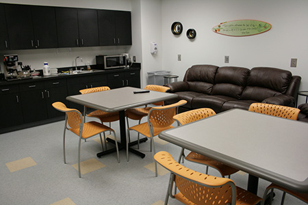 a breakroom with multiple tables and chairs
